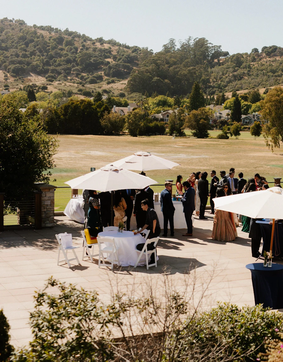 Guests gathered outdoors under umbrellas